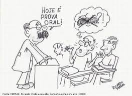 Professor em pé na bancada lecionando e informando que o teste do dia é prova oral